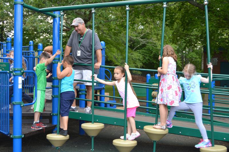 Mickey Raposo keeps a watchful eye on his kindergarten students as they try out the playground at DeMello Elementary. BY SETH THOMAS