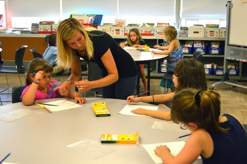 Julia Mullins, the art teacher at DeMello Elementary, assists kindergarteners through an art lesson during Transition Day. BY SETH THOMAS