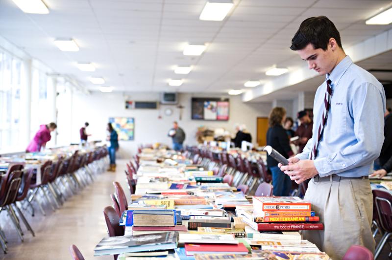 Volunteer and Bishop Stang senior Dylan Giblin stacks and organizes the books to be sold. BY DOLLY GENANNT