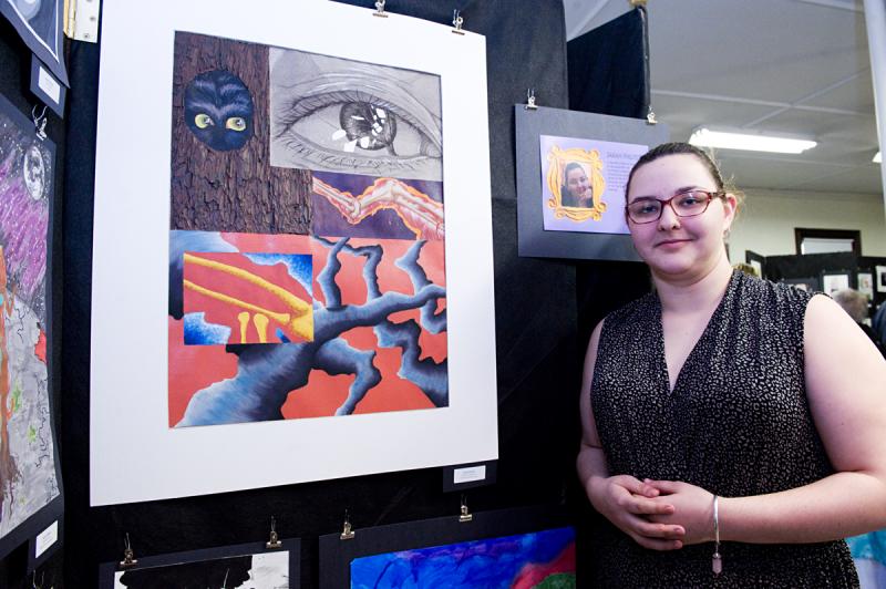 Senior Sarah Philpott stands beside a piece of artwork that was displayed at UMass Dartmouth's CVPA Gallery. BY DOLLY GENANNT