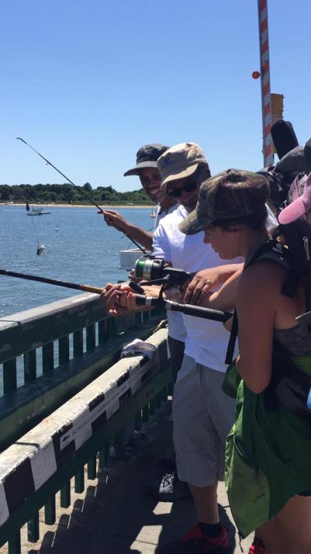 John Perez of Brockton lets Alvey reel in a Monkfish he caught off the Padanaram Bridge. BY ANGIE HILSMAN