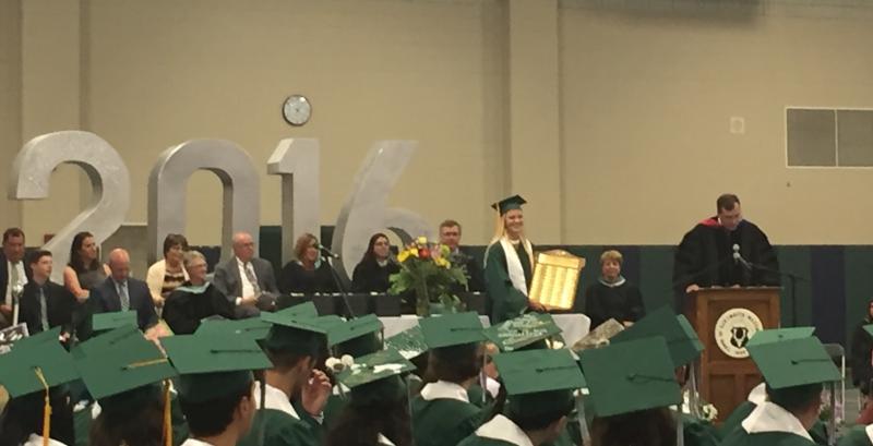 Valedictorian Jennifer Wheaton holds the plaque engraved with the school's first-ranking graduates. Her name will be the most recently added to the plaque which sits in the school's lobby. BY ANGIE HILSMAN