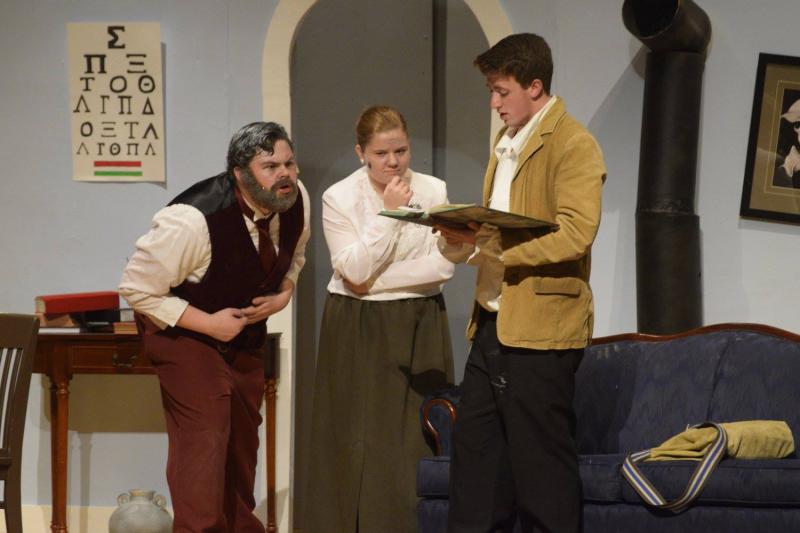 Kempton Campbell (Dr. Zubritzky), Julia Olimpio (Mrs. Zubritzky), and Austin Watts (schoolmaster Leon Tolchinsky), read the curse that made the whole village stupid. COURTESY DARTMOUTH HIGH THEATRE COMPANY/ FACEBOOK