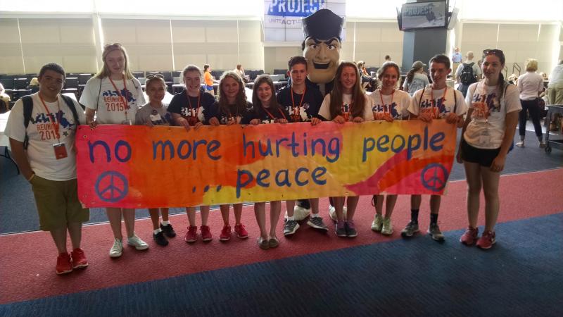 Smialek holds a sign from the walk honoring Martin Richard. The quote is from a school project the eight-year-old boy had created. COURTESY SARAH SMIALEK