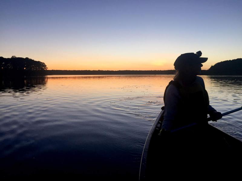 The lighting was perfect to capture the sun setting on canoers attending the Lloyd Center's women-only canoe trip on the Slocum River on September 16. Here, Jane Scott paddles back towards the Lloyd Center. BY ANGIE HILSMAN