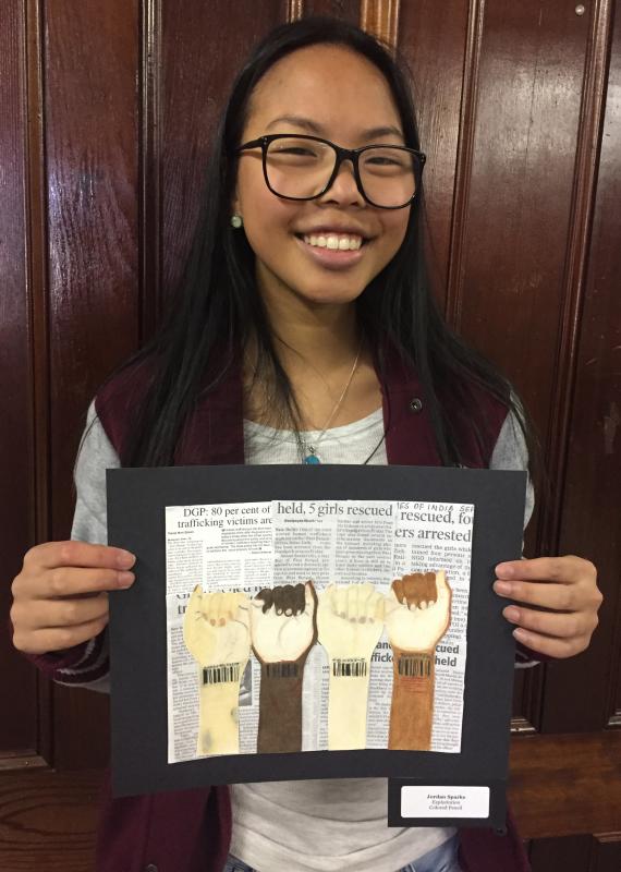 Dartmouth High senior Jordan Sparks holds up her piece, titled "Exploitation," which is comprised of colored pencil and newsprint. BY ANGIE HILSMAN