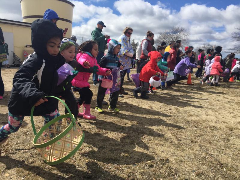 Upon receiving the green light, nearly 100 kids race across Apponagansett Park to gather candy-filled Easter eggs. BY ANGIE HILSMAN