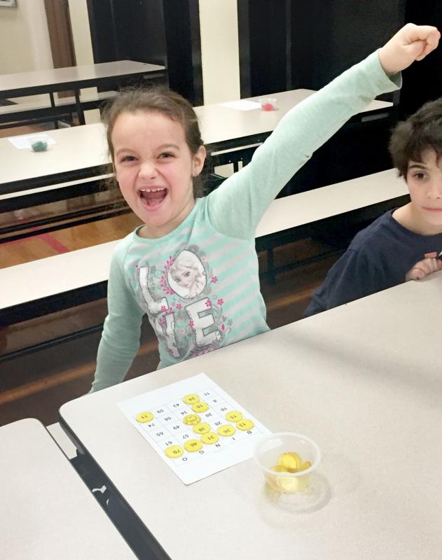 Mary Jenna Avila, 7, celebrates after winning the first round of bingo at DeMello Elementary on April 13. BY ANGIE HILSMAN