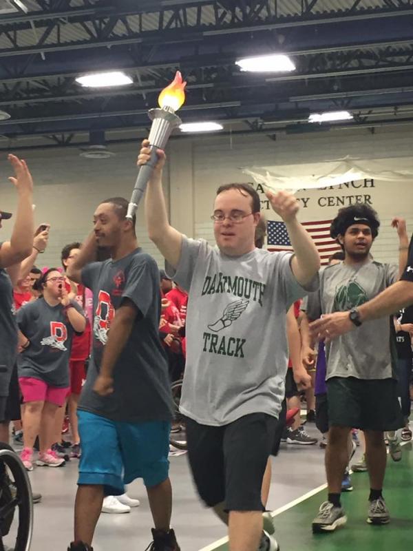 Dartmouth High alumnus Shawn Lvesque, 33, carries the torch in to start the Special Olympics games. BY ANGIE HILSMAN