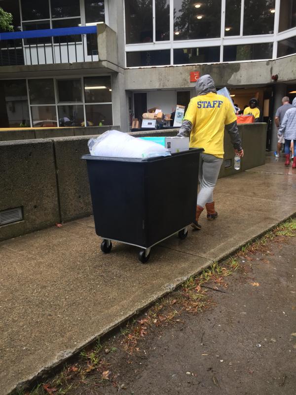 Resident assistants and volunteer students help wheel carts of freshman belongings into the resident halls. BY MARY MACEDO