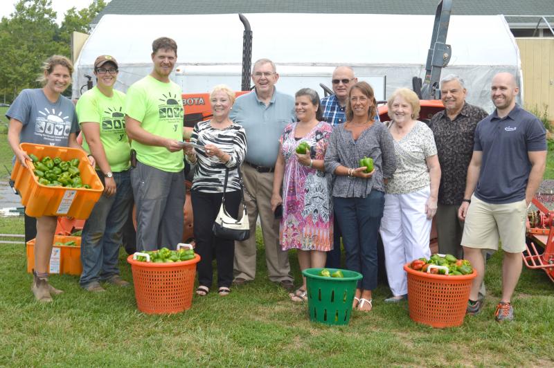 The Sharing the Harvest Community Farm receives a donation from the Friends of the Elderly. From left: Emily Secor, Emma Rainwater and Dan King of the farm; Maria Connor, Bill Anderson, Deb Raymond, Wayne Whalley, Nancy Miller, Ellie White and Ron Souza of Friends of the Elderly/Council on Aging; and Mike Mahoney of the YMCA. BY SETH THOMAS