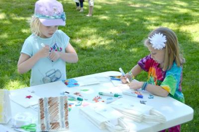 Jillian DuBois, 6, and Kasey Bernat, 6, use markers and stickers to design the front of their loot bags. BY SETH THOMAS