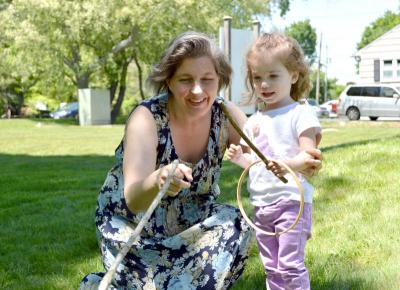 Sarah Labossiere and Aurelia Tufano, 2, play a game of Graces, a game where two players pass a wooden ring back and forth. BY SETH THOMAS