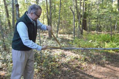 Executive Director Dexter Mead cuts a branch with a pair of golden loppers – an earthier version of a ribbon cutting ceremony. BY SETH THOMAS