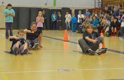 Competitors in "Minute to Win It" try to balance plastic eggs on spoons while sliding across the gym. BY SETH THOMAS