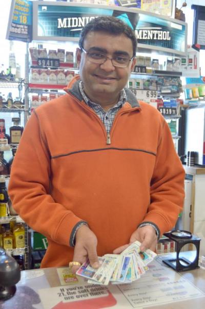 Yogi Patel, owner of Town Liquors, shows off a small sampling of the fake IDs he's collected from underage shoppers who have attempted to buy alcohol in his store. BY SETH THOMAS