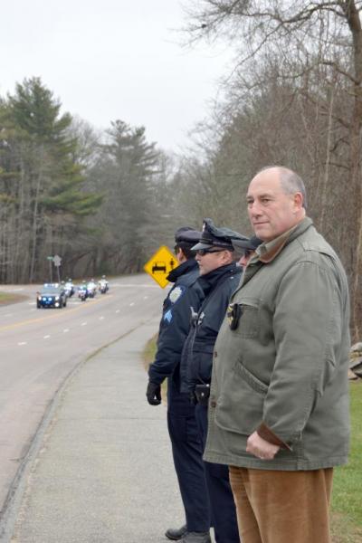 Captain Timothy Sheehan and officers from the UMass Dartmouth Police Department await the funeral procession to pass by on Old Westport Road. BY SETH THOMAS