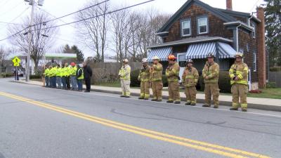 Firefighters and members of the community stand on the side of Russells Mills Road during the procession. COURTESY DCTV