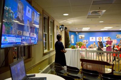 A news anchor from WPRI conducts an interview while a nearby TV and laptop play the feed. BY SETH THOMAS