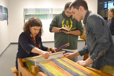 BFA Textile Design/Fiber Arts student Christopher Rogers (right) teaches Rabbi Jacqueline Satlow (left) how to weave. BY SETH THOMAS