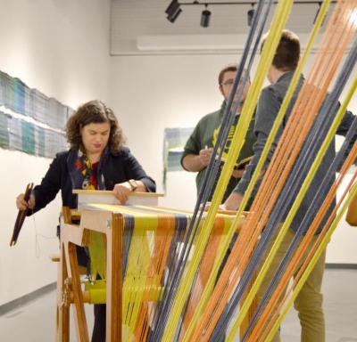 Rabbi Jacqueline Satlow creates a textile at the "Weaving in Light" exhibit at UMass Dartmouth. BY SETH THOMAS