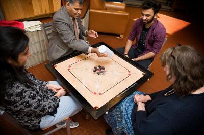 Professor Satya Parayitam spreads chalk on the game to make the chips slide easier. BY DOLLY GENANNT