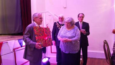 Dartmouth Town Administrator David Cressman presenting a gift of thanks to Gina Coles of the sister city delegation from Dartmouth, England. COURTESY CYNDI MARLAND
