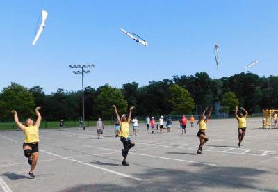 Gigi Chedid, Jesse Walker, Ryley Thatcher, and Jaeda Walker toss their rifles in the air. Photo by: Chloe Shelford