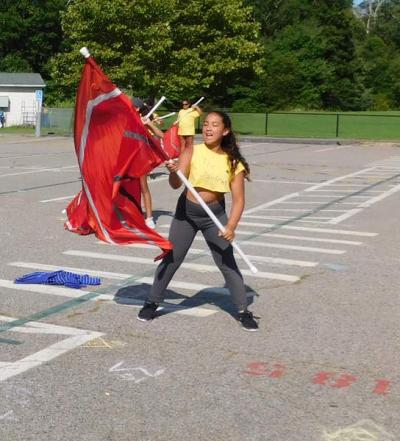 A member of the junior varsity color guard practices some new choreography. Photo by: Chloe Shelford