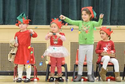 Chloe Clark, Margaret Sommer, Hannah Gabriel, and Hadley Soares dress up as Christmas lights during a song. Photo by: Douglas McCulloch