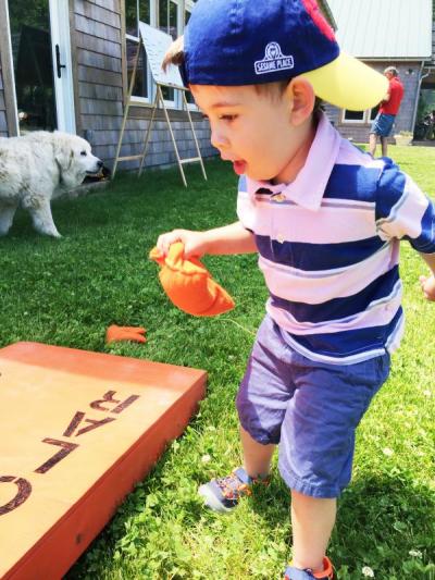 Three-year-old Preston Hermenegildo playing corn hole