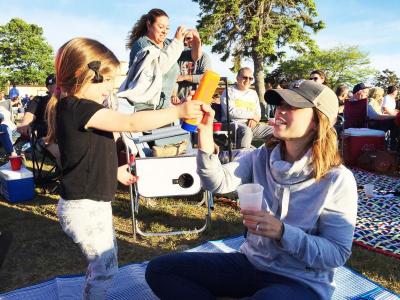 Julia Sylvia, 3, hands her mother Monica the sunscreen