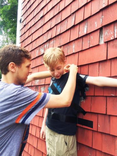 Kenny, 19, tapes his 13-year-old brother Ben to the wall of a barn