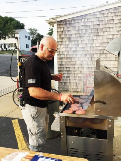 Department member Charlie Silvia grills some meat for the cookout