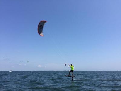 A kiteboarder rides on his foil during a practice run before the start of the race