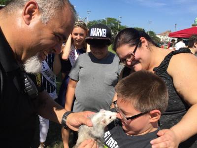 Gage Kendrick, 9, gets a nuzzle from Slinky the ferret while his mother and Maciel look on.