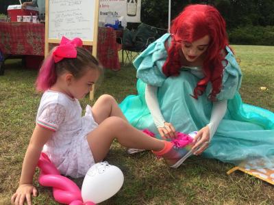 Princess Ariel not only played drums and signed autographs — she also helped Savannah Woodcock, 6, with her shoes.