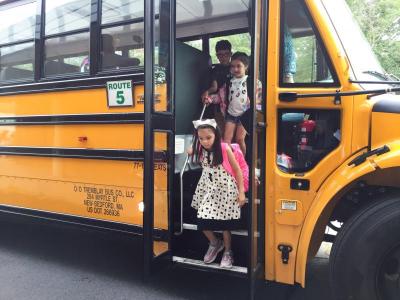 Ivy Arelo steps off the bus to head to her first day in first grade at the Potter School.