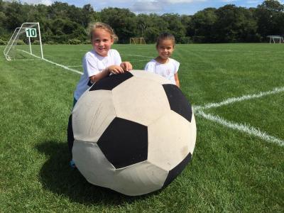 Regan Wilson and Averie DaCosta, both 5, play with a giant soccer ball.