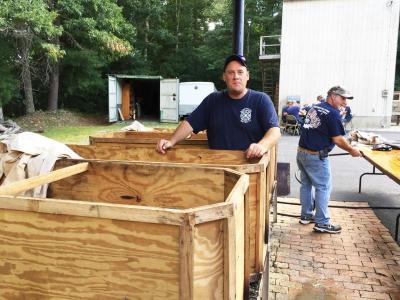 Bake master Kenny Gidley shows the plywood “coffins” he and Fire Chief Tim Andre built to bake the clams.