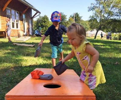 Calum, 4, and Scarlett Walker, 1, play their own version of corn hole.