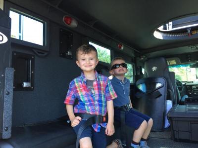 Aidan Levesque, 4, explores the inside of the S.W.A.T. van with his friend Gabriel Kelley, 4, of Melrose.