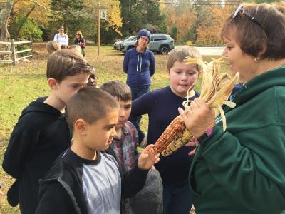 DNRT President Lorraine Granda shows colorful Indian Corn to the students, explaining that when it pops, the colors remain.