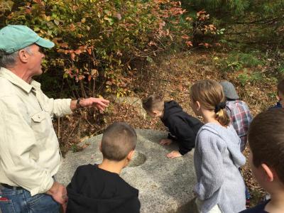 DNRT volunteer Tom Matthews tells the students the running stone weighs about 3,000 pounds, or 1.5 tons.