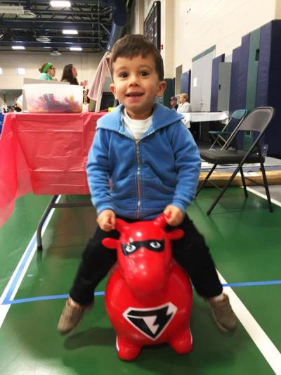 James Cabral, 3, bounces on an inflatable animal.