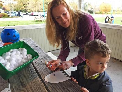 Susan Peachey helps son Thomas Kenney, 2, with a cotton ball ghost craft.