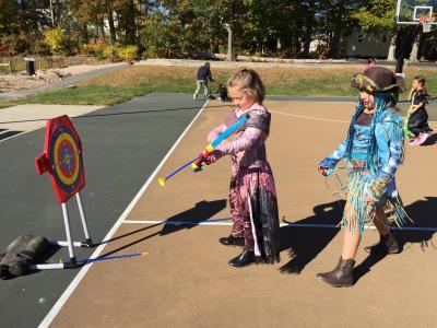 Seven-year-old Avery Imbeau tries her hand at archery while her friend Hayden Camara, 8, looks on.
