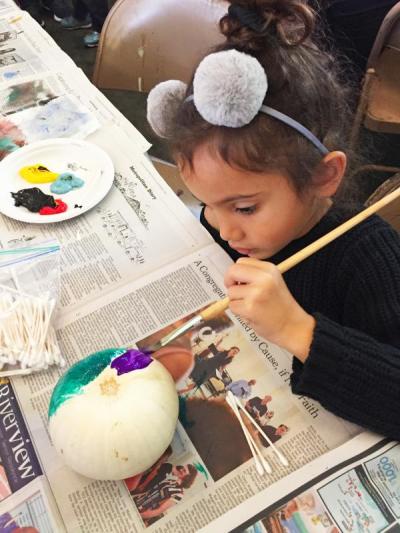 Kennedy Whitfield, 4, adds purple to what will be a rainbow pumpkin.