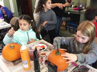 Mia Gomes, 8, paints her Foxy the Pirate-themed pumpkin while her friend Lucy Muldoon, 7, prepares to paint hers.