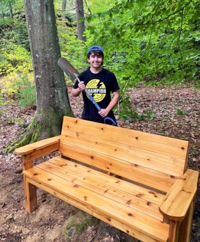Andrew Magalhaes at Destruction Brook Woods in front of one of the benches he built near the vernal pool. Photo courtesy: DNRT